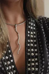 Gargantilla rígida plateada con dije colgante en forma de rama. Hecha a mano en alpaca.