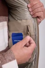 Chaleco acolchado sin mangas color beige, con cuello alto y cierre de cremallera.