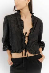 Blusa color blanco de lino, con mangas 3/4 y volados en el frente. Se ata con lazos en el centro.