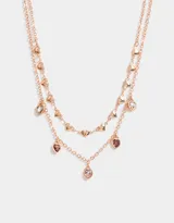 Collar corto multicadena bañado en oro rosa, con corazones y strass, con cierre de mosquetón.