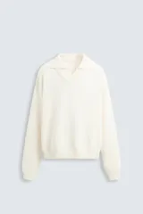 Sweater color crema de punto con cuello polo y escote en V.