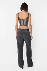 Corset lencero en tejido desagujado con foil, color gris con detalles plateados. Recortes en delantero con ballena en interior. Busto con aro; taza media copa y superposición de breteles. Terminaciones con elástico dobladillado por interior. Acceso por espalda con cierre metálico YKK desmontable.