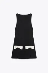 Vestido corto negro sin mangas, con cuello redondo y detalle de lazos blancos en la parte inferior.