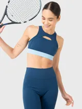 Top deportivo azul con detalle de abertura en la parte frontal sobre el busto y almohadillas removibles.