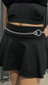 Cinturón plateado tipo caderín con strass y doble aro entrelazado.