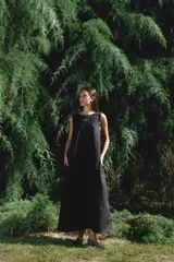 Vestido largo negro sin mangas, corte amplio y cuello redondo con abertura en forma de gota. Incluye bolsillos laterales. 