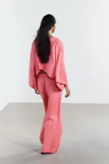 Pantalón de tiro alto color rosado, confeccionado en hilatura con lino, de pierna ancha y cintura elástica ajustable con cordones.