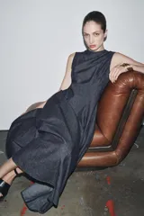 Vestido midi de denim azul oscuro, con cuello redondo y sin mangas. Corte entallado en la cintura y falda evasé. Cierre trasero con cremallera oculta.