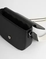 Bandolera negra de cuerina con solapa bordada y correa regulable de tela con rayas blancas y negras.