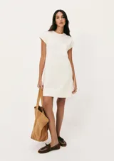 Vestido corto color crema, de corte recto y mangas cortas con bolsillo en el pecho.