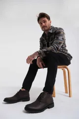 Bota de cuero marrón oscuro con cordones, suela de goma y diseño clásico.