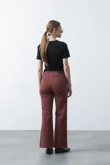 Pantalón negro de tiro alto, corte recto y silueta clásica. Presenta costuras verticales marcadas en la parte delantera de las piernas.