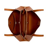 Cartera tote Guess modelo Sora, tamaño mediano, color marrón con logo triangular metálico en el frente y llavero colgante con el nombre de la marca. Tiene doble asa de hombro y cierre superior con cremallera.