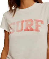 Remera blanca con cuello redondo y estampado frontal con la palabra 'SURF' en color coral.