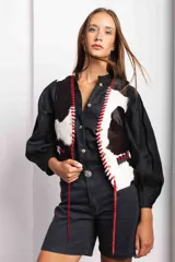 Chaleco con estampado de vaca en tonos marrones y blancos, con detalles de pasamanería en cuero.