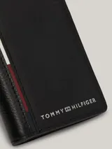 Billetera plegable de cuero negro con paneles de diferentes texturas y detalle de logo de Tommy Hilfiger en el frente.