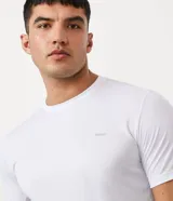 Remera deportiva blanca de poliéster, con cuello redondo, mangas cortas y recortes laterales.