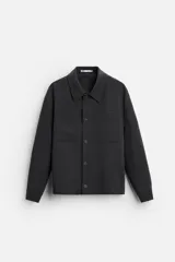 Sobrecamisa negra de corte cuadrado, con cuello solapa, manga larga con puños abotonados, bolsillos de parche en el pecho, bolsillos laterales y cierre frontal con botones.