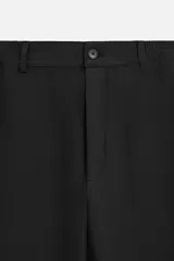 Pantalón negro de corte recto con cintura elástica, bolsillos delanteros y traseros. Cierre frontal con cremallera y botón.