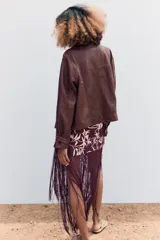 Cazadora marrón de cuero con cuello solapa y manga larga con trabillas. Tiene bolsillos de vivo y con solapa en delantero, detalle de costuras marcadas y cierre frontal con cremallera y botón a presión ocultos por sopata.