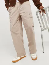 Pantalón cargo color beige de pierna ancha con fit amplio y tiro medio alto. Cuenta con bolsillos delanteros, traseros y laterales, cierre con cremallera y puños doblados.