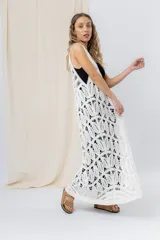 Chaleco largo tejido en punto calado color beige, de silueta recta y caída fluida. Presenta un diseño artesanal con transparencias sutiles que aportan textura y movimiento.