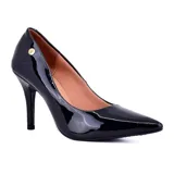 Zapato de tacón alto Korium, color negro charol, con punta fina y detalle de logo dorado en el lateral.