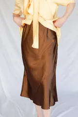 Falda midi color marrón de satén al bies con cintura elástica.