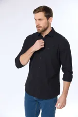 Camisa de lino color beige, de manga larga, con cuello clásico y bolsillo en el pecho.