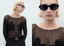 Jersey de punto calado negro con cuello barco y detalles florales bordados.