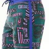 Short de baño Rip Curl Mirage Max Quest, con estampado geométrico en tonos verde, violeta y rosa. Cintura elastizada en color azul con cordón ajustable.