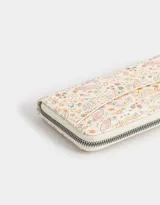 Billetera con cierre, formato fichero, de cuerina color crudo con estampado de flores y cachemir.