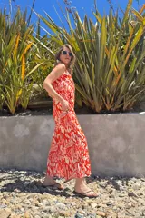 Mono largo de fibrana con estampado abstracto en tonos rojo y blanco, con breteles finos y corte palazzo.