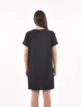 Vestido negro de corte recto, con mangas cortas y bolsillo en el pecho.