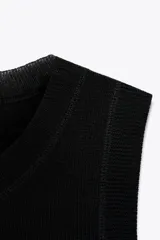 Top negro de punto liso, cuello redondo y sisa.
