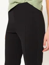 Pantalón negro de punto tramado con cintura elastizada, corte al cuerpo y tajos en el ruedo.