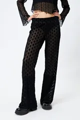Pantalón de encaje negro con transparencias y cintura con elástico.