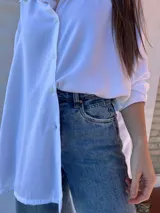 Camisa negra de corte amplio, con mangas largas y puños abotonados.