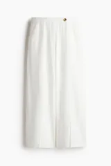 Pantalón sastrero blanco tobillero de tiro alto, con cierre y botón, bolsillos al bies, bolsillos traseros decorativos y piernas amplias con pliegues adelante y atrás. Confeccionado en tejido liviano de lino y viscosa.