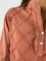 Blusa de viscosa color gris, con diseño texturizado y cuello tipo mao, de manga larga.