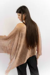 Poncho tejido color cobre con apliques de piedras y flecos.