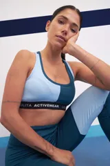 Calza deportiva larga de tiro alto, color azul con paneles laterales en celeste y blanco.