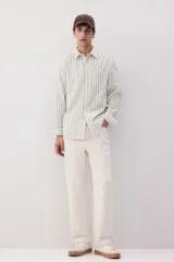 Camisa de manga larga con cuello inglés, a rayas verticales grises y blancas, con bolsillo en el pecho.
