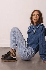 Zapatillas bajas de cuero negro con cordones y suela de goma color caramelo.