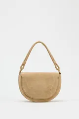 Bandolera de gamuza color beige, con asa corta y cierre imantado.