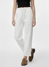 Pantalón tipo jogger de tiro alto, color blanco, con cintura elástica y cordón ajustable.