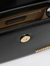 Bolso estructurado de piel lisa color borgoña, con asa reforzada de hebilla metálica, solapa magnética y asa bandolera ajustable y extraíble. Cierre de mosquetón grabado, bolsillo interior y logotipo frontal. Forrado completamente en algodón.