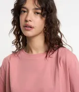 Remera rosa de algodón con cuello redondo, manga corta, pliegues en los hombros y elástico en el bajo.