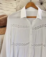 Vestido/camisa blanca de manga larga con detalles de encaje calado.