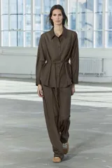 Pantalón de tiro medio color marrón, con cintura elástica ajustable con cordones, bolsillos delanteros y traseros, raya planchada y pierna recta.